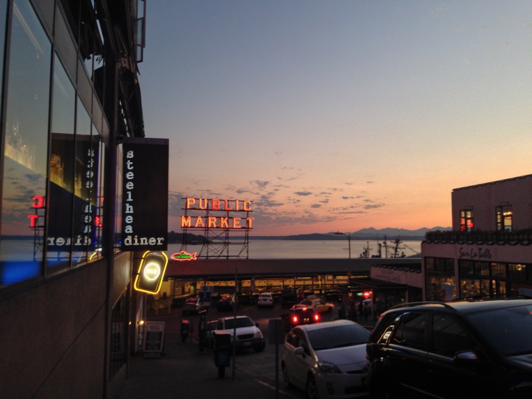 Pike Place Market with Puget Sound and the Olympic Mountains on the horizon.